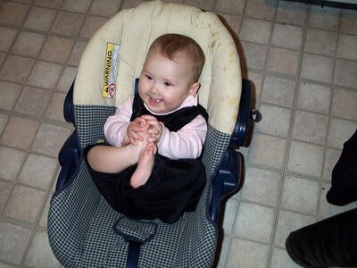Me smiling in my carseat holding my feet